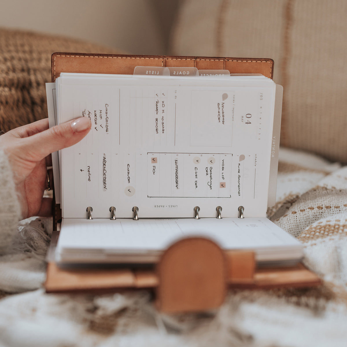 Hand holding an open ring planner with a printable daily planning page